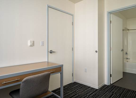 A room with a desk and chair in it.