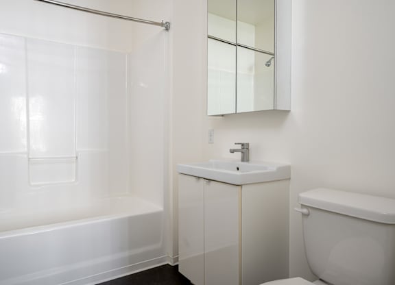 A white bathroom with a sink, toilet, and bathtub.