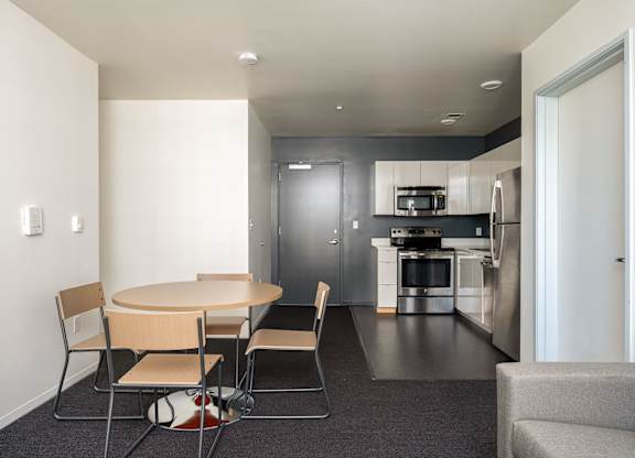 A modern kitchen with a dining table and chairs.