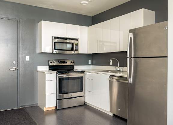 A modern kitchen with stainless steel appliances and white cabinets.