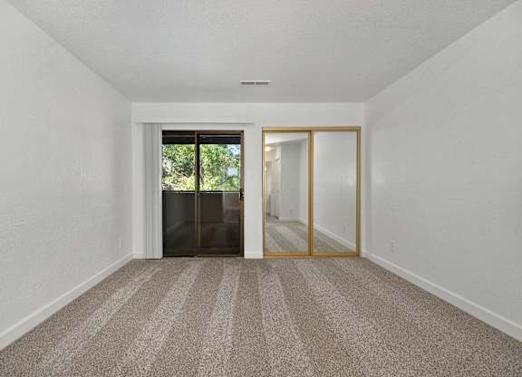 2 BR Apartments in Tracy CA - Townhomes at 201 - Bedroom with Carpet Flooring, Oversized Closet, and Access to Patio/Balcony