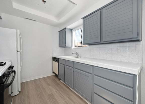 Townhouses for Rent in Tracy, CA - Townhomes at 201 - Kitchen with Grey Cabinetry, Speckled Countertops, and Wood-Style Flooring