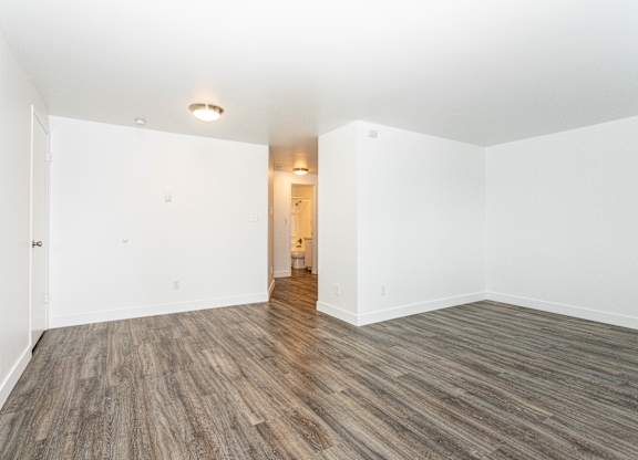 A room with wooden flooring and white walls.