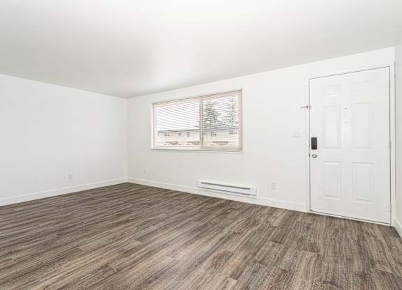 A room with a white door and a window with blinds.