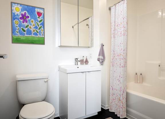 A white toilet sits next to a white sink in a bathroom.