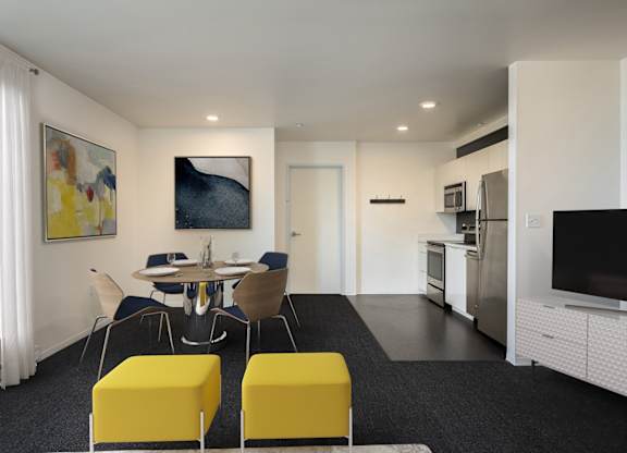 A modern kitchen with a dining table and chairs.