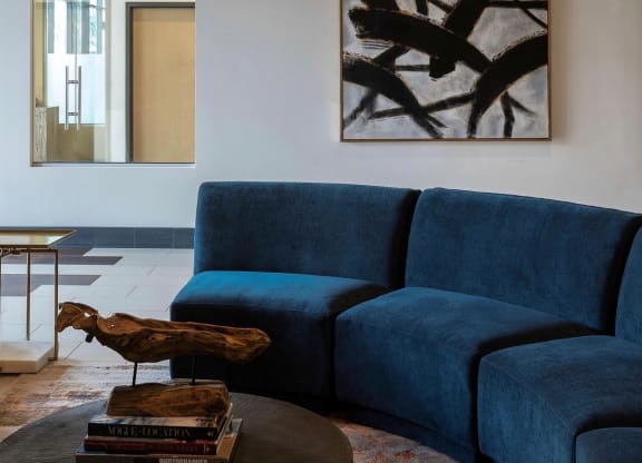 a blue couch in a living room with a table and a bird statue