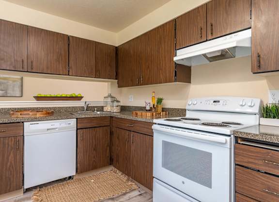 Model Kitchen with wood cabinetry and white appliances