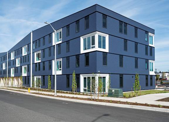 A modern blue building with white trim and windows.