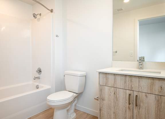 A white toilet sits next to a white sink in a bathroom.
