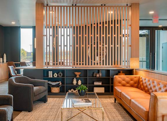 A modern lounge room with a wooden partition and a glass coffee table.