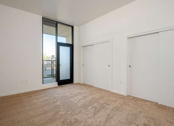A room with a carpeted floor and a sliding glass door.
