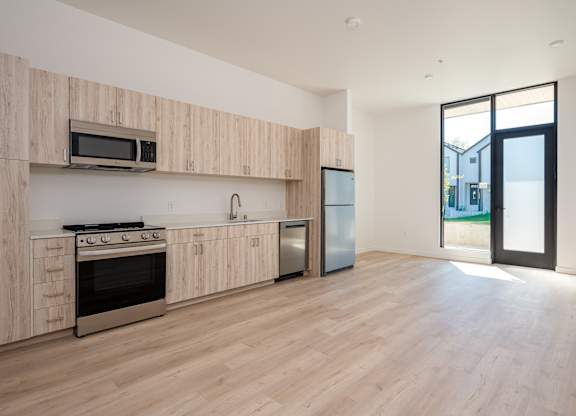 A kitchen with wooden cabinets and a stainless steel refrigerator.