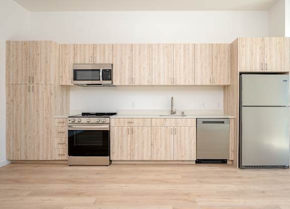 A kitchen with wooden cabinets and stainless steel appliances.