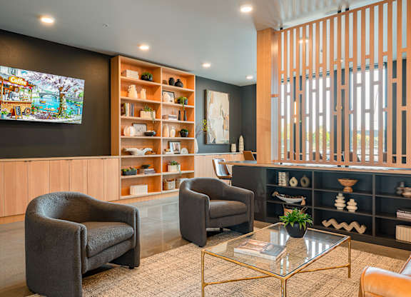 A lounge room with a television, two chairs, and a coffee table.