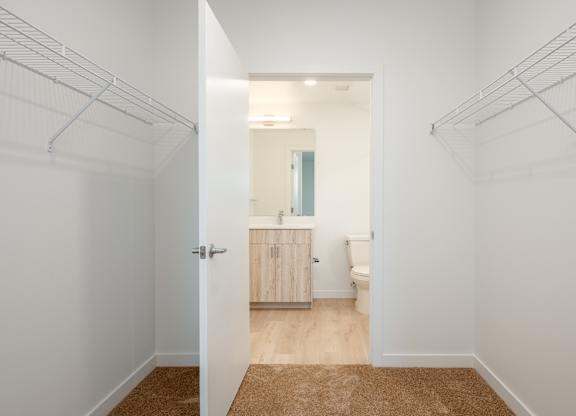 A hallway with a doorway leading to a bathroom.