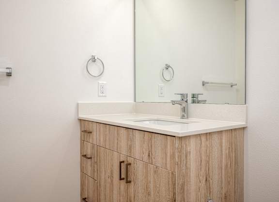 A bathroom vanity with a sink and mirror.