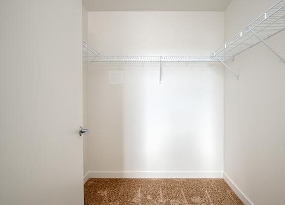 A white room with a brown carpet and a white door.
