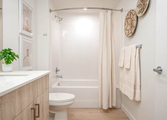 A white bathroom with a toilet, sink, and shower.