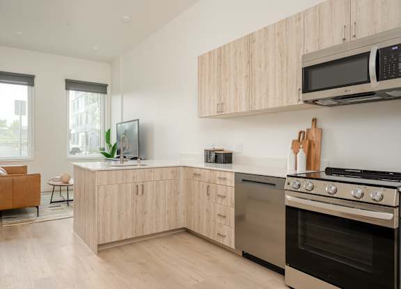 A modern kitchen with wooden cabinets and stainless steel appliances.