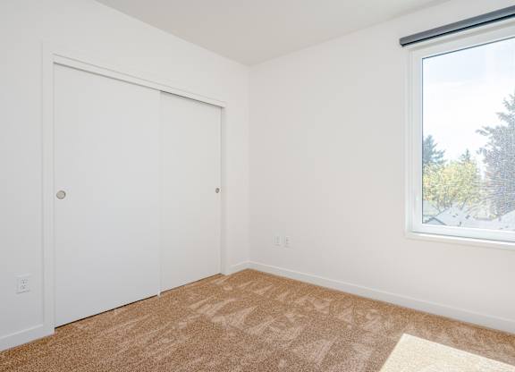A room with a white door and a carpet on the floor.