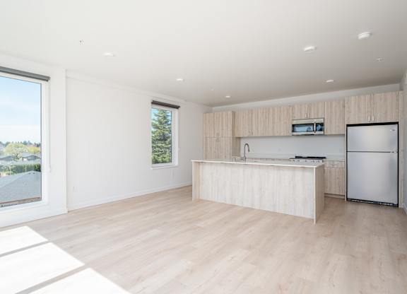 A modern kitchen with a refrigerator, sink, and countertop.