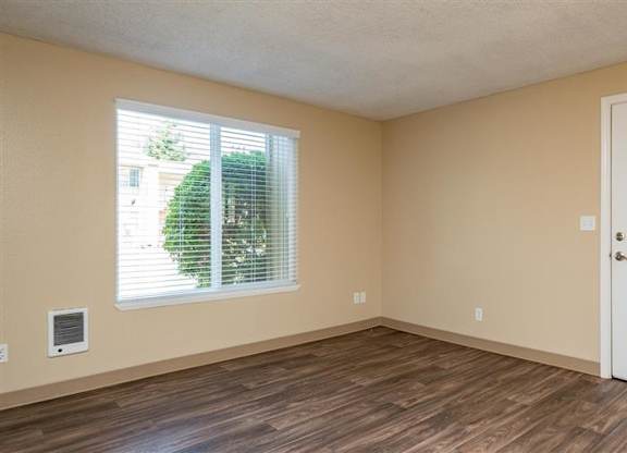 A room with a white door and a window with blinds.