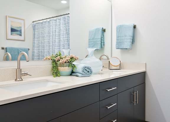 A bathroom with a sink, mirror, and towels.