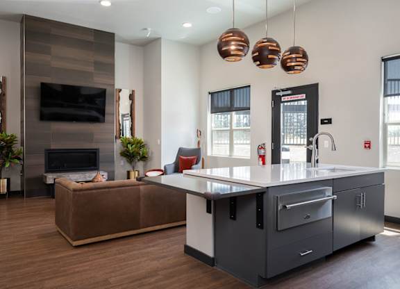 A modern kitchen with a brown sofa and a wooden floor.