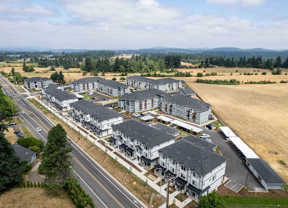 A large housing development with multiple buildings and a road running through it.