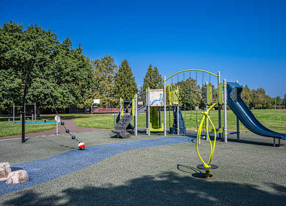 A playground with a blue slide and a yellow swing set.