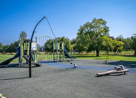 A playground with a green slide and a blue slide.