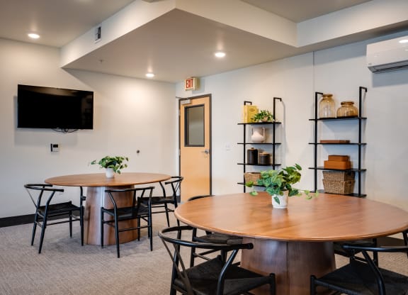 a dining room with tables and chairs and a tv on the wall