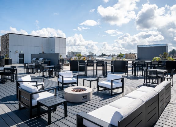 a roof top patio with furniture and a fire pit
