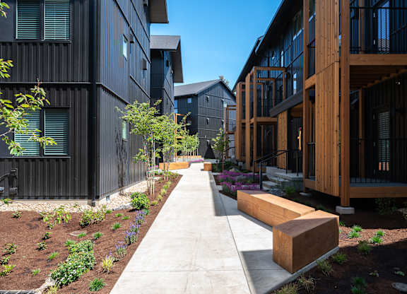 A long concrete walkway leads between two buildings.