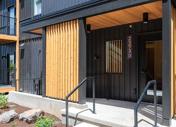 A black and wooden building with the number 2373D on the door.