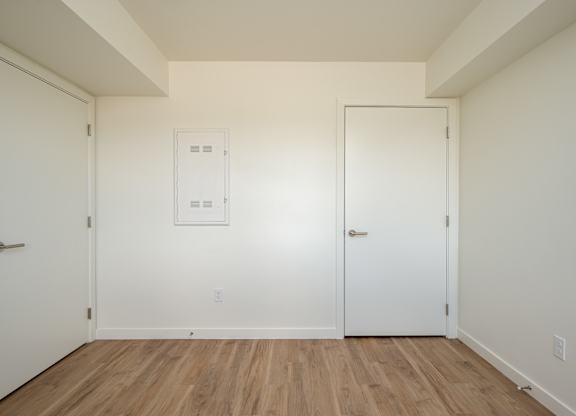 A room with two doors and a white framed window.