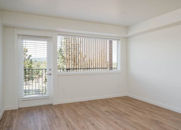 A room with a white door and a window with blinds.