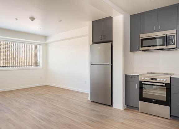 A kitchen with a stainless steel refrigerator, oven, and microwave.