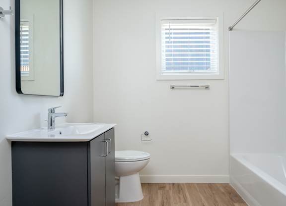 A bathroom with a toilet, sink, and bathtub.