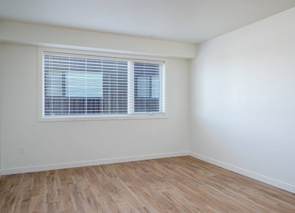 A room with a window and wooden flooring.