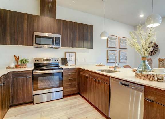 A modern kitchen with wooden cabinets and stainless steel appliances.
