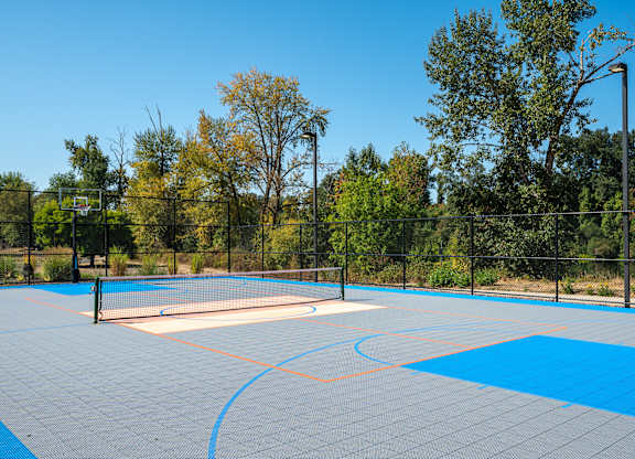 A tennis court with a blue surface and a white net.