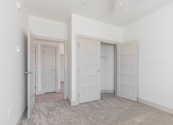 A room with two doors and a carpeted floor.