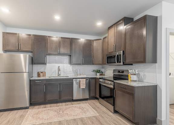 A modern kitchen with stainless steel appliances and wooden cabinets.