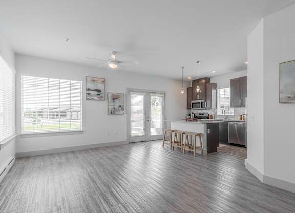 A spacious kitchen and dining area with wooden flooring and white walls.