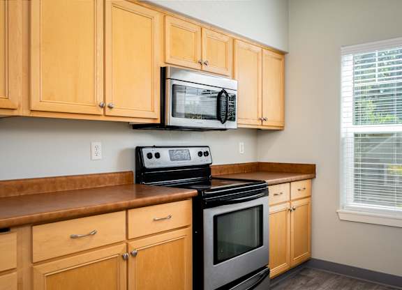 A kitchen with wooden cabinets and a black stove top oven.