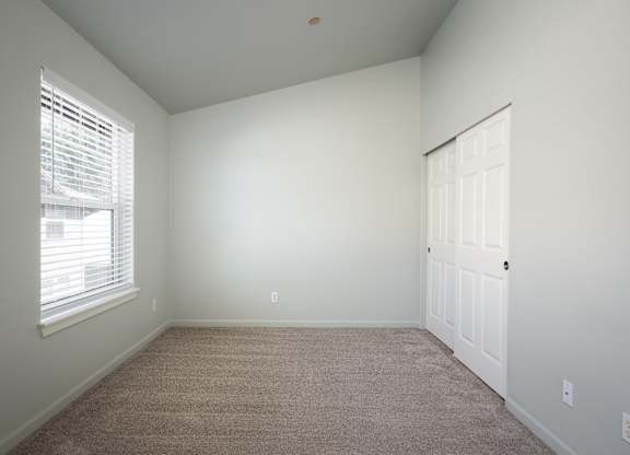 A room with a carpeted floor and a white door.
