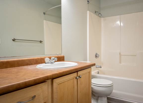 A bathroom with a toilet, sink, and bathtub.