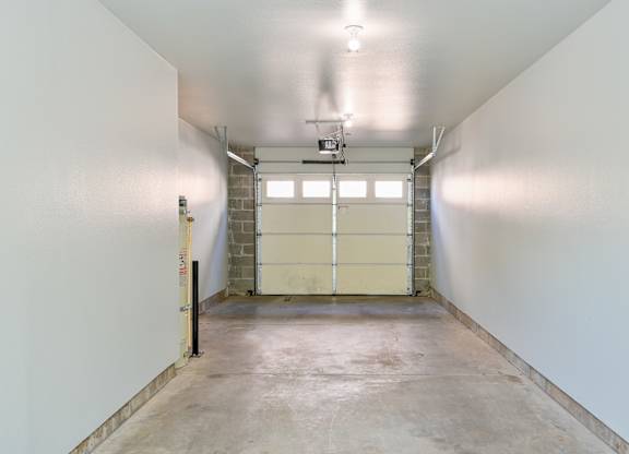 A large, empty room with a concrete floor and white walls.